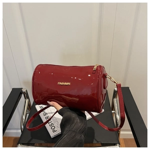 Détail du sac cylindre en cuir verni rouge brillant avec logo FASHION doré