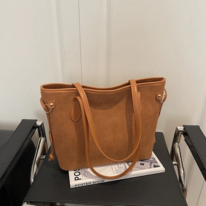 Brown vintage suede tote bag with leather handles on a black chair, 2025 casual style