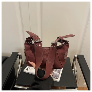 Close-up of wine red tote bag with adjustable silver eyelet straps and smooth texture