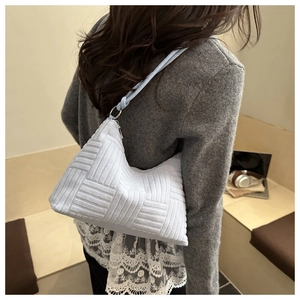 Détail d'un sac cabas lavande à texture tissée avec une bandoulière au style minimaliste