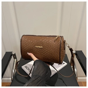 Détail macro du tissage marron et du logo Fashion doré sur le sac Boston cylindrique