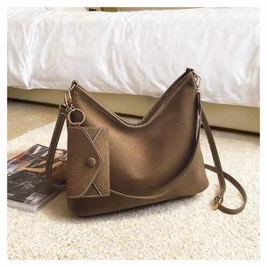 Detail of dark brown hobo shoulder bag with golden hardware and matching mini pouch