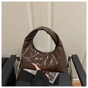 Detailed view of dark brown hobo bag featuring glossy patent leather and vertical stitching