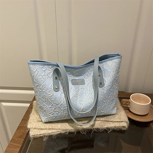Fashionable light blue tote bag with star stitching and a comfortable shoulder strap