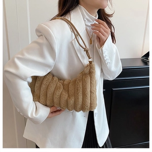 Detail of plush faux fur shoulder bag with vertical stripes and sleek thin strap