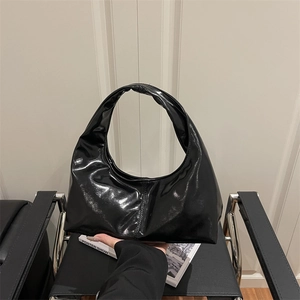 Minimalist black shiny hobo bag with a pleated design and a seamless single handle