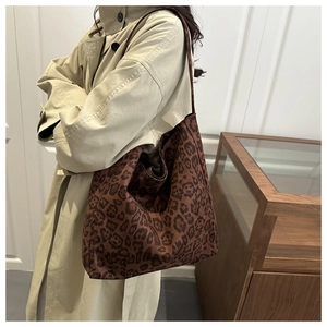 Detail of a large leopard print canvas tote bag with thick texture and shoulder straps