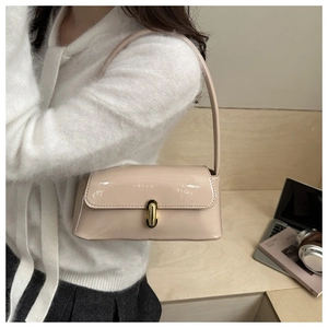 Detailed close-up of glossy patent leather handbag with gold rectangular buckle lock