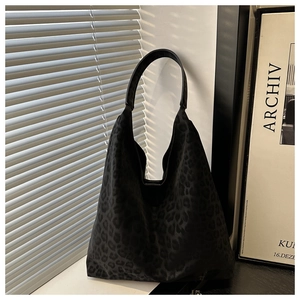 Détail du sac hobo léopard noir avec texture en toile et large bandoulière