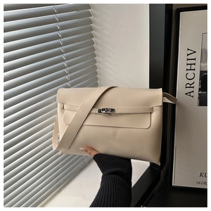 Dettaglio della borsa beige minimalista con chiusura a scatto argento e cinturino in pelle