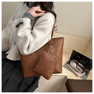 Detailed view of brown faux leather tote bag set with mini pouch and lychee texture