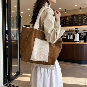 Brown faux suede tote bag with white faux fur trim and front pocket for winter fashion