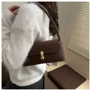 Détail du sac à bandoulière léopard avec boucle dorée sur un pull en fausse fourrure