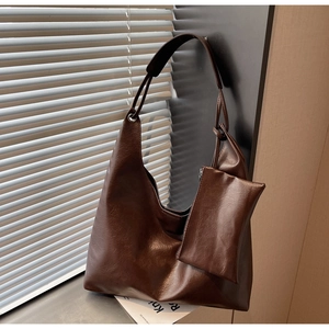 Detail of dark brown oil wax leather hobo bag with a matching mini detachable zipper pouch