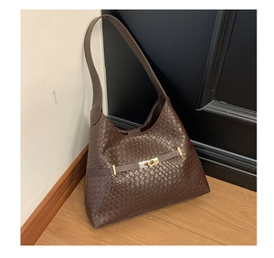 Close-up of woven leather texture on a dark brown hobo bag with a gold metal twist lock