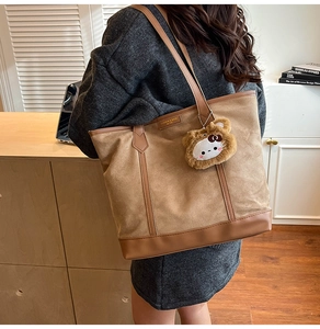 Fashionable khaki canvas tote bag with leather straps and bear mascot detail