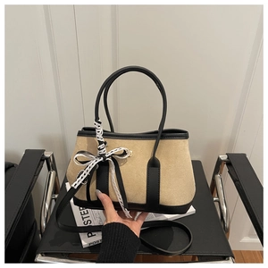 Détail du cabas beige avec boucle dorée et décoration de nœud en dentelle élégant