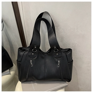 Detail view of black lychee leather tote bag with functional side pockets and zippers
