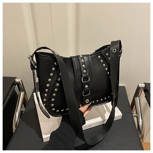 Close-up of a black punk-style saddle bag with silver rivets and magnetic buckle strap