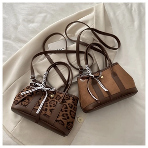 Détail de sacs à main léopard et daim marron avec bandoulières en cuir et boucles dorées