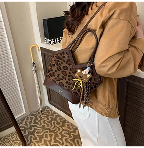 Détail du sac léopard avec garniture en cuir marron et accessoire charm d'ours mignon