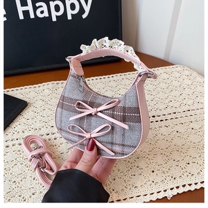 Detail of grey plaid mini crescent bag featuring pink bows and white lace handle decoration