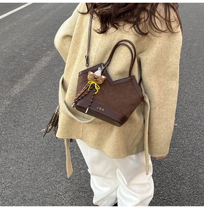 Détail du sac à main marron foncé avec logo JDH et pendentif en forme d'ours mignon