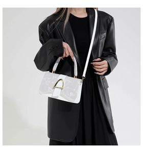 Détail du sac bandoulière blanc avec imprimés géométriques et boucle fer à cheval dorée
