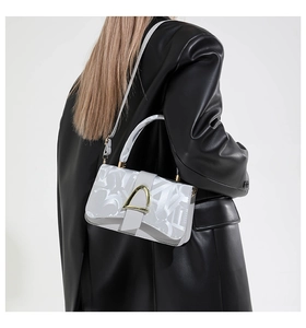 Détail du sac bandoulière gris avec motif abstrait et fermoir métallique doré en D