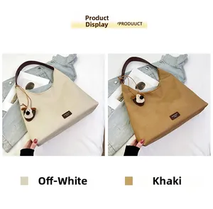 Detail of canvas tote bags in beige and khaki with leather handles and dog plush charm