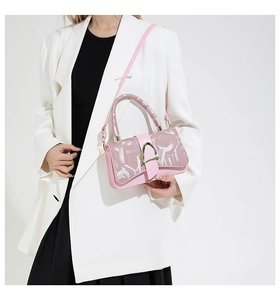 Détail d'un sac à bandoulière rose à monogramme avec boucle D dorée et finition cuir