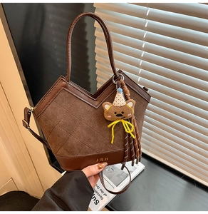 Détail du sac bandoulière matelassé marron foncé avec pendentif ours et sangle