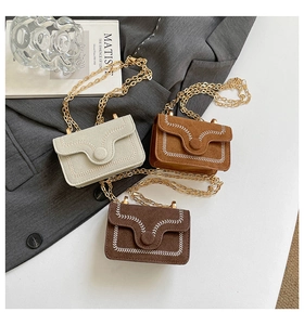 Detailed macro view of suede crossbody bags with stylish white contrast stitching details
