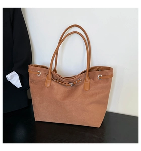 Detail of large brown suede tote bag with drawstring texture for casual office commuting