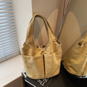 Minimalist khaki multi-pocket tote bag in a spacious bucket design for women