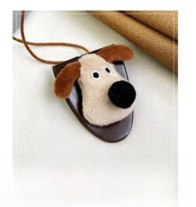 Detailed view of the cute plush cartoon dog charm with brown leather base and hanging strap