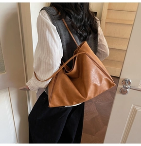 Detailed back view of large caramel brown tote bag showing leather texture and long straps