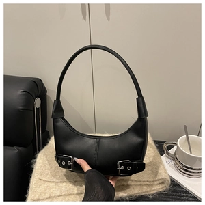 Detail of black crescent hobo bag featuring silver buckle accents on a leather base