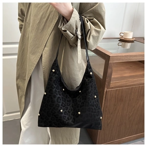 Detail der Hobo-Tasche mit Leopardenmuster, goldfarbenen Nieten und Leder-Schultergurt