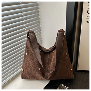 Nahaufnahme der Hobo-Tasche mit Leopardenmuster, Goldnieten und breitem Lederriemen