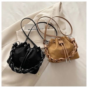 Detail of suede drawstring bucket bags with woven handles and leather textures