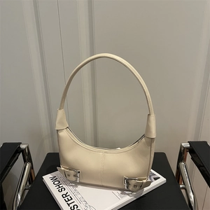 Minimalist beige moon-shaped crescent hobo bag with silver buckles and leather handle