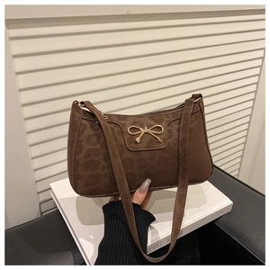 Close-up of vintage brown leopard print shoulder bag with golden bow buckle detail