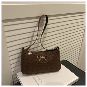 Close-up of leopard print shoulder bag with gold bow clasp and flower zipper detail