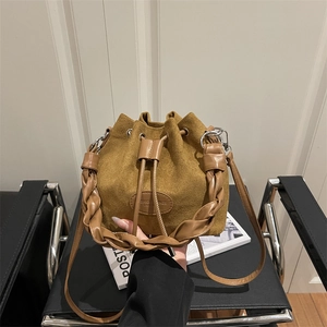 Retro mustard yellow suede bucket bag with woven handle and drawstring closure