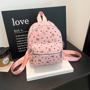 Mini zaino in velluto a coste rosa con cuori e fiocchi su sfondo stile di vita