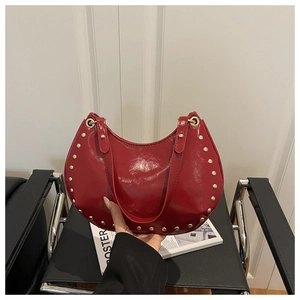 Vue détaillée d'un sac demi-lune en cuir verni rouge avec des rivets dorés élégants
