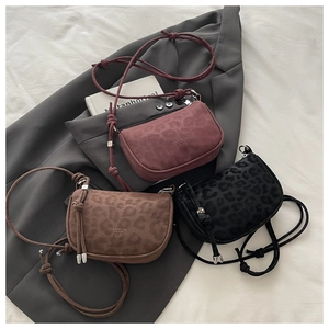 Detailed view of leopard print crossbody bags in burgundy, brown, and black leather