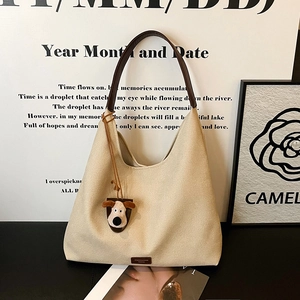 Chic beige canvas hobo tote bag with dark brown leather straps and cute dog charm pendant