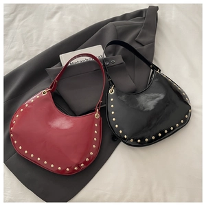 Détails des sacs sous le bras en cuir verni rouge et noir avec ornements à clous dorés